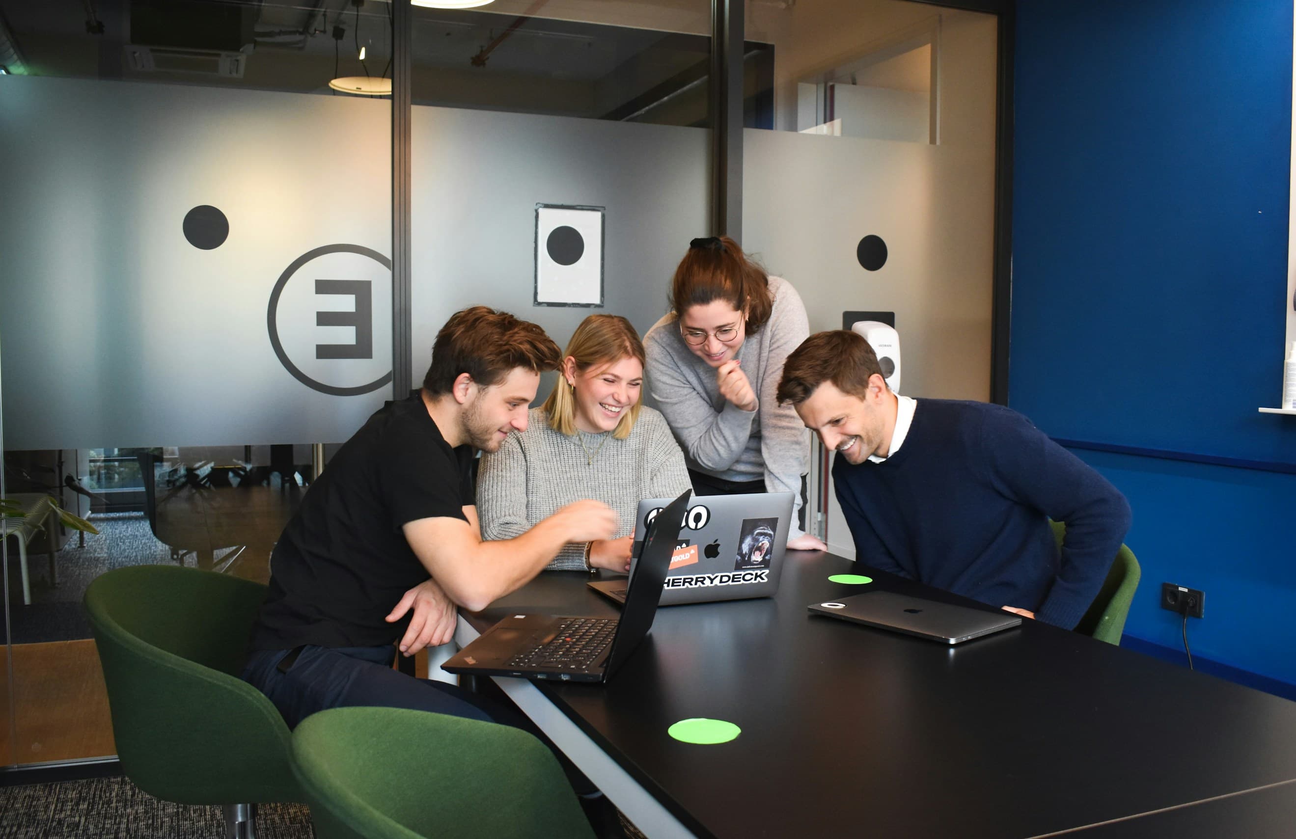 EcoBeam Studio team collaborating around a laptop
